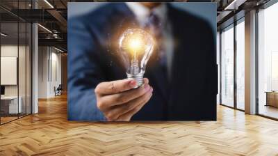 Hand holding drawing virtual lightbulb with brain on bokeh background for creative and smart thinking idea. Generated image Wall mural