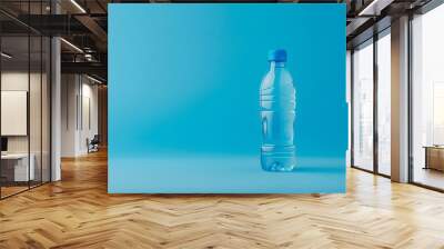 A vibrant mockup of a blank bottle of water on a solid blue background Wall mural