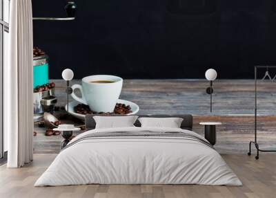 Coffee mill and cup of espresso. Concept of coffee drinking tradition. Selective focus. Wooden table, coffee beans. Black background. Wide panoramic image. Copy space. Wall mural