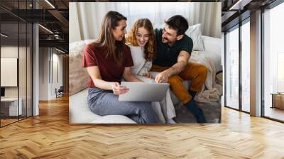 Family exploring online where to go on a vacation. Wall mural