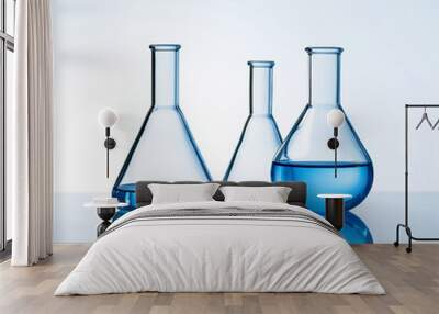 Three erlenmeyer laboratory flasks with blue liquid against a white background.   Wall mural