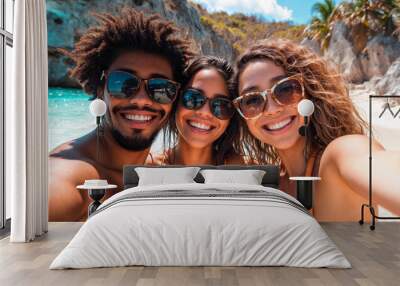 Friends on a beach taking a selfie style photograph smiling and happy with the calm clear ocean behind them Wall mural