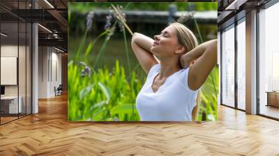 relaxation outside - smiling young woman daydreaming,enjoying sun and vacation with green surrounding, summer daylight Wall mural