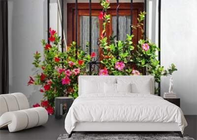 Blooming mallows decorating the window of a white house Wall mural