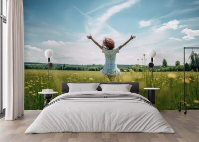 Carefree young woman in white summer dress enjoying the freedom in the vast blooming field. Happy girl with spread arms running in the green field. Wall mural