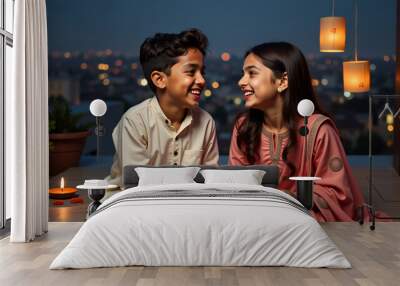 Siblings share Indian sweets on a modern rooftop with Diwali lanterns and city lights. Festive rooftop setting with minimal Diwali decorations and siblings in ethnic attire. Wall mural