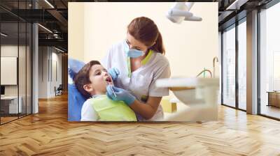 A child with a dentist in a dental office. Dental treatment in a children's clinic. Wall mural