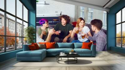 A group of friends of students at a meeting communicates together sitting on a sofa in a room. Wall mural