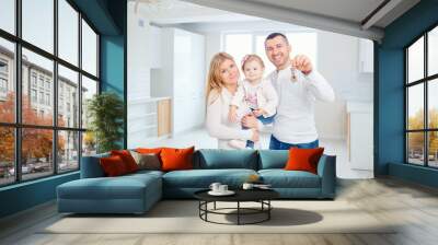 A happy family moves to a new apartment. Mother, father and child with boxes in the room of the new house. Wall mural