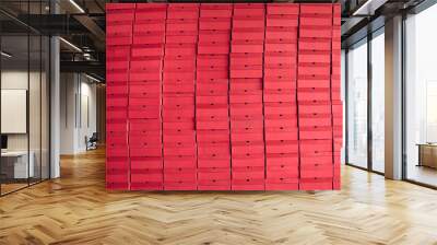 Background of multiple red cardboard package boxes with footwear stacked at a shoe factory warehouse. Shoe manufacturing industry, bulk trade, distribution and business concepts Wall mural