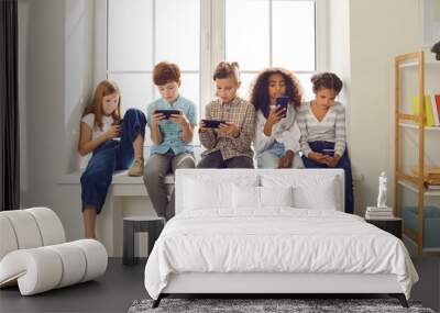 Children of different nationalities play online games or read social networks on mobile phones. Wall mural