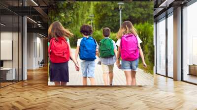 Children on their way to school. Group of little kids going to class. Six male and female students with colorful red, green, yellow, blue and pink backpacks walking along the park path. Banner, header Wall mural