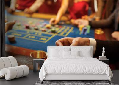 Chips in the hands of a man at a casino roulette table. Wall mural