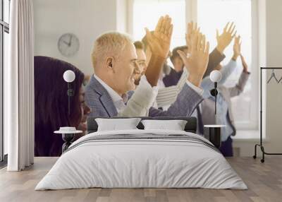 Close up portrait of a happy smiling joyful business people voting at the conference standing in a row in office. Team of company employees raising their hands up to answer a question on a meeting. Wall mural