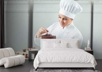 Confectioner decorating chocolate cake in pastry shop. Wall mural