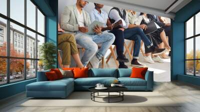 Crop image of diverse employees sit on chairs in row listen to seminar or training in office. Job candidates or applicants in line wait for interview for vacant position. Employment, hiring concept. Wall mural