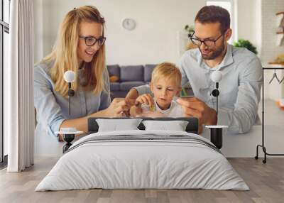 Curious little kid saving up money and learning about financial literacy from young parents Wall mural