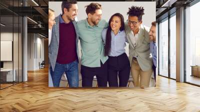 Diverse business team having fun in the office. Group of happy, joyful multiracial people standing in the office, huddling, and smiling. Banner, header background. Teamwork concept Wall mural