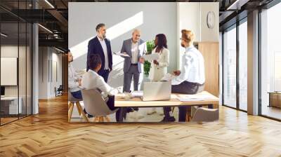 Diverse multiracial corporate business team having work meeting together. Group of six young and senior mixed race multiethnic people discussing their strategy in company office with laptop Wall mural