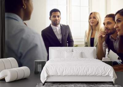 Diverse team of friendly people meeting in office and talking. Group of multi ethnic men and women sitting in circle and listening to woman telling story, giving advice or suggesting business solution Wall mural