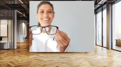 Doctor giving you new prescription glasses. Happy optometrist showing modern good quality eyeglasses. Optometry, eyewear, eye health concept. Grey text copyspace banner background, closeup, close up Wall mural