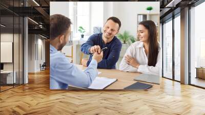 Family couple, as customers, signing a contract with a financial consultant or investment agent during an office meeting. This signing marks an important step in investment journey. Wall mural