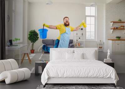 Funny fat man cleaning gloves is cleaning in the room. Wall mural