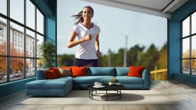 Girl runner runs along the road Wall mural