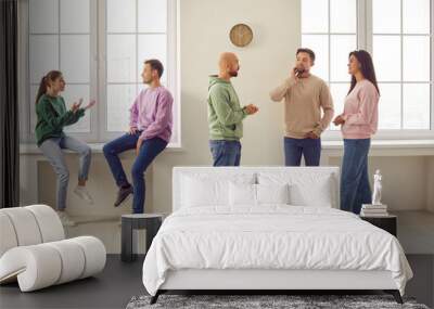 Group of business people or students in casual clothes men and women chatting on a meeting. Company employees or friends team talking and communicating with each other gathering indoors. Wall mural