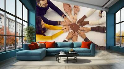 Group of different people following God's word together. Several young and senior brothers and sisters in Christ holding hands on Bible and praying during religious meeting at small Christian church Wall mural