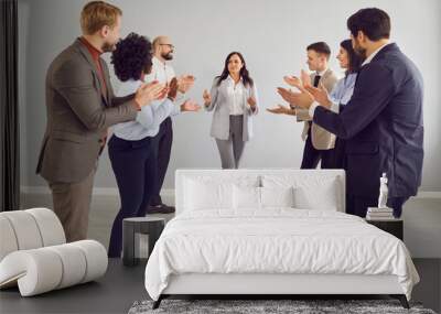 Group of happy funny young business people or company employees wearing office suits having fun celebrating their success or making a good deal in indoors congratulating their female colleague. Wall mural