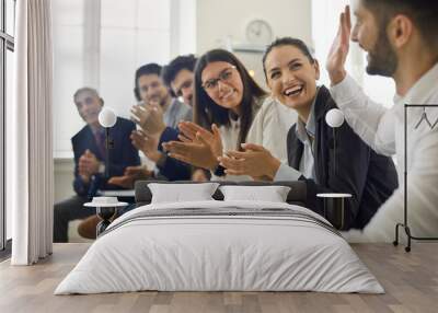 Group of people thanking speaker for interesting presentation in professional business conference or seminar. Team of happy male and female company workers applauding colleague in corporate meeting Wall mural