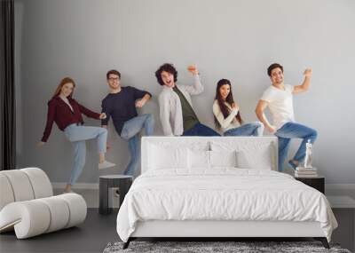 Group of young people in casual clothes smiling while gray background. Wall mural