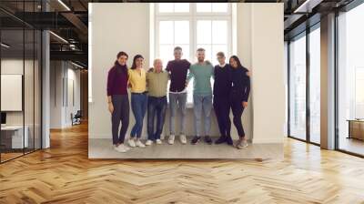 Group portrait by the window of happy positive diverse people of different genders, races and ages. Wall mural