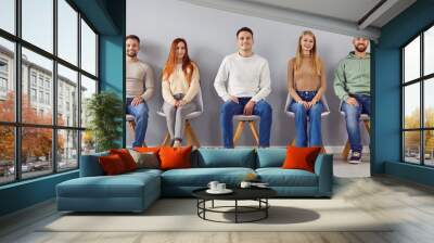 Group portrait of young smart people chair sitting in easy pose, one vacant place left. Diverse new company, together as team, friends gathered showing liking, affection, fellows in good relationships Wall mural