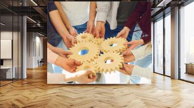 Groups of young people hold gear hands. Wall mural