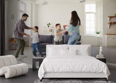 happy cheerful family playing and having fun at home. joyful excited mom, dad and children dancing a Wall mural