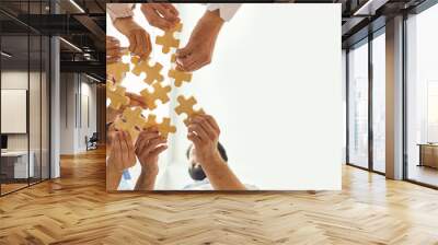 Happy company employees joining parts of jigsaw puzzle during work meeting or team building activity Wall mural