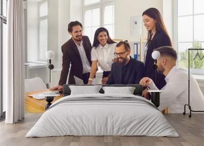 Happy company workers gather in office and use laptop computer for marketing research or video call Wall mural