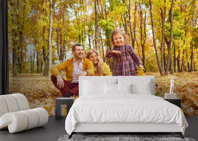 Happy family playing in the park in the fall. Wall mural