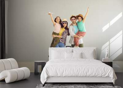 Happy family tourist portrait. Father, mother and two daughters ready for travel flight posing to camera with suitcase waiting for aircraft arrival. Airport departure studio background with copy space Wall mural