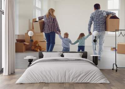 Happy family with children moving with boxes in a new apartment house. Wall mural