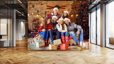 Happy friends with Christmas gifts near holiday tree Wall mural