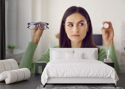 headshot portrait of woman choosing between glasses and eye lenses. serious beautiful caucasian girl Wall mural