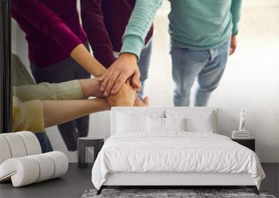 High angle close-up of team of people joining their hands united by a common goal Wall mural