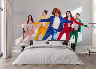 In step with style. Group of five cheerful people coordinated in dance line dance dressed in bright stylish suits. Beautiful creative people dancing showing teamwork, fashion, joy and rhythm of life. Wall mural