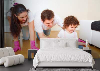 Mother, father and daughter playing on the floor in the room whi Wall mural