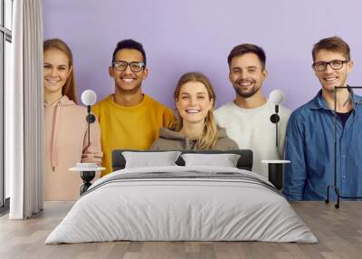 Portrait of group of young, smart and positive multiracial people on purple background. International students who are dressed in casual clothes and smiling confidently looking at camera. Banner. Wall mural