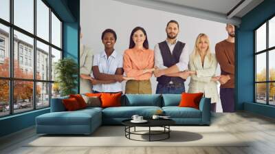 Portrait of successful group of business people standing together in row and holding hands. Multiracial people on light background. Concept of strong community, mutual assistance and support. Banner. Wall mural