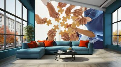 Positive company workers playing with jigsaw puzzle during team building activity Wall mural